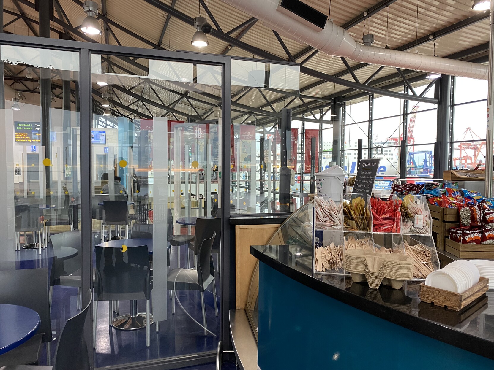 A chaotic image of a cafe counter and glass partitions separating public and checked-in areas.